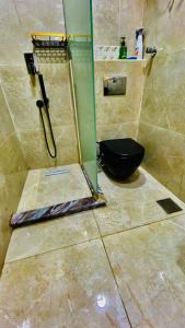 a bathroom with a shower with a black toilet at Emerald flat in Marsa Alam City