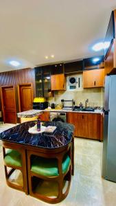 a large kitchen with a table and a refrigerator at Emerald flat in Marsa Alam City