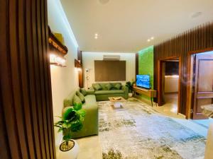 a living room with a green couch and a television at Emerald flat in Marsa Alam City