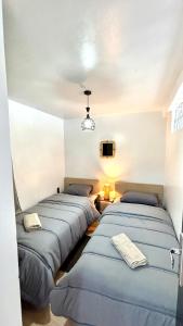three beds are lined up in a room at Surf house apartment in Oualidia