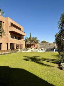 a building with a large lawn in front of it at Neper Hotel in Córdoba