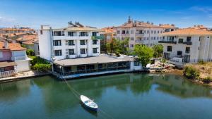 a boat in a river in a city with buildings at Olive Branch Hotel in Ayvalık