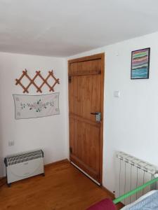 a bedroom with a wooden door and a crib at Апартамент Стар стил Old style in Raduil
