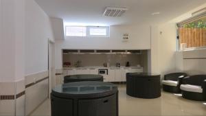 a kitchen with black stools and a glass table at Apartments Philip II in Ohrid