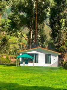 a white house with a green tent in a field at Hotel Bellavista in Calca