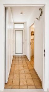 an empty hallway with a door and a tile floor at Strandläufer in Wendtorf