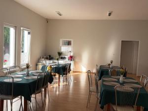 a room with tables and chairs with green tablecloths at Las i Morze - Dźwirzyno in Dźwirzyno