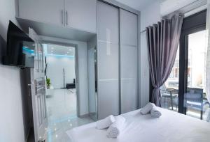 a bedroom with a white bed and a large window at Aurelio Luxury Apartments in Paloúkia