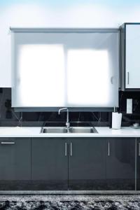 a kitchen with a sink and a white counter top at Aurelio Luxury Apartments in Paloúkia +12 photos