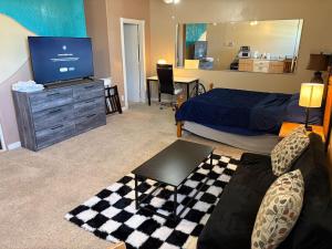 a bedroom with a bed and a tv and a couch at EmERALD loft studio SWiMMiNG pool kitchen DwNTwN in Phoenix