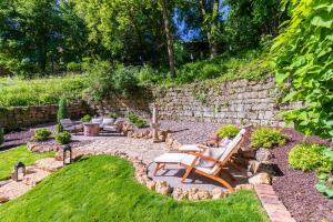a garden with a stone wall and two chairs and a bench at Harvest and Hearth in Galena