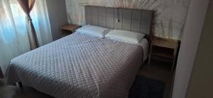 a bedroom with a white bed with two pillows at Via Roma Residence in Maniago