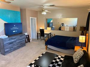 a bedroom with a bed and a flat screen tv at EmERALD loft studio SWiMMiNG pool kitchen DwNTwN in Phoenix
