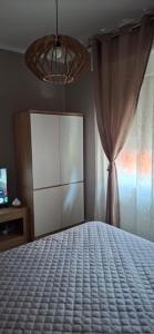 a bedroom with a bed with a dresser and a curtain at Via Roma Residence in Maniago