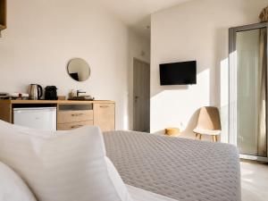 ein weißes Schlafzimmer mit Bett und Küche in der Unterkunft Aqualis in Adamas