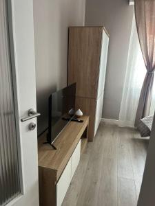 a living room with a tv on a wooden cabinet at Via Roma Residence in Maniago