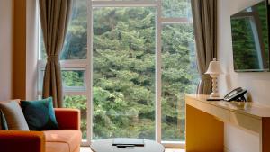 a living room with a large window and a couch at Potalaka Naksan Beach Wellness in Yangyang