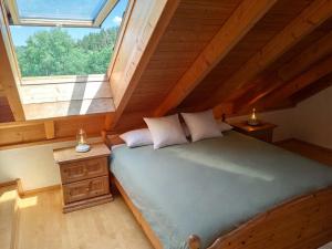a attic bedroom with a bed and a window at Chalet-Loft im Schwarzwaldhof Wutachblick in Bonndorf im Schwarzwald +11 photos