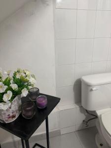 a bathroom with a table with flowers and a toilet at casa granada en Carranza in San Luis Potosí