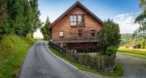 an old brick house on a road with a fence at Chalet-Loft im Schwarzwaldhof Wutachblick in Bonndorf im Schwarzwald