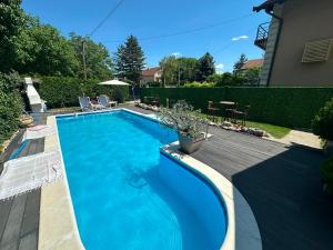 a swimming pool in a yard with a wooden deck at La dolce vita in Novi Banovci