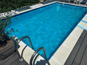 a swimming pool with a chair next to it at La dolce vita in Novi Banovci
