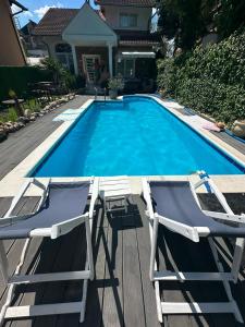 two lawn chairs and a swimming pool with two chairs at La dolce vita in Novi Banovci