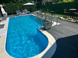 a large blue swimming pool next to a wooden deck at La dolce vita in Novi Banovci +43 photos