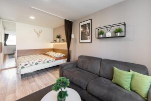 a living room with a couch and a bed at Apartmány Stožec - Nella Premium in Stožec
