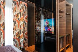 a bedroom with a tv in a wooden cabinet at Hotel Orizzonte in Giugliano in Campania