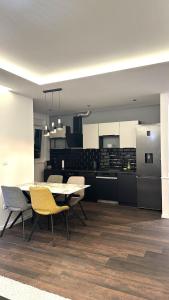a kitchen with a table and chairs and a refrigerator at Apartment Niko in Posušje