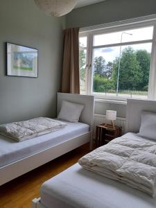 two beds in a room with a window at Det Gamla Postkontoret in Råda +17 photos