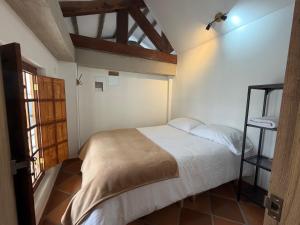 a bedroom with a white bed and a window at Hostal Boutique Loto de Belén in Bogotá
