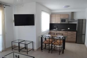 a kitchen with a table and chairs and a tv at Montaña Tirba in Costa Calma