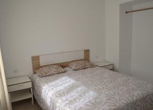 a bedroom with a bed with two nightstands and two tables at Montaña Tirba in Costa Calma