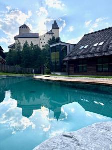 a pool of water with a castle in the background at Residenz zur Hackenschmiede in Mauterndorf