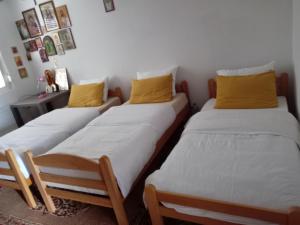 two twin beds in a room with yellow pillows at Sobe Andjela in Arilje +1 photo