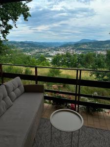 a couch and a table on a balcony with a view at Sobe Andjela in Arilje
