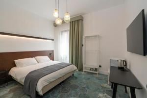 a bedroom with a bed and a desk and a television at Ca'santoro 3 in Agerola