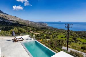 a villa with a swimming pool and a view of the ocean at Kaliva Villa in Kerames