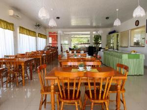 a dining room with wooden tables and chairs at Pousada Vó Santina in Protásio Alves