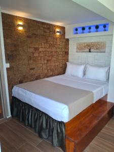 a bed in a room with a brick wall at Luxury Private Suite in Rhodes Town