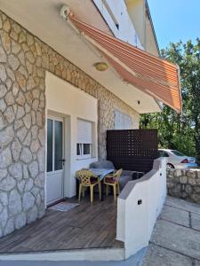 patio ze stołem i krzesłami obok budynku w obiekcie TANY w mieście Dramalj