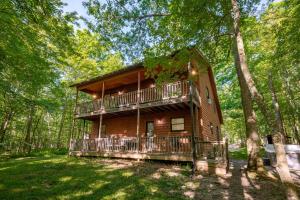 a log cabin in the woods with trees at Peace at Last by Railey Vacations in McHenry
