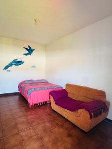 a living room with a couch and a bed at Habitación 11 Posada Itzel in Oaxaca City