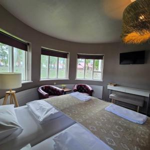 a bedroom with a bed and two chairs and windows at Akureyri Hostel in Akureyri