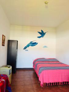 a bedroom with a bed with two dolphins on the wall at Habitación 11 Posada Itzel in Oaxaca City +5 photos