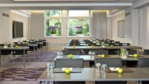 ein großer Raum mit Tischen und Stühlen und Fenstern in der Unterkunft InterContinental Berlin by IHG in Berlin + 281 Fotos
