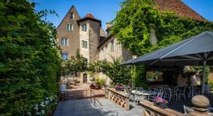 an outdoor patio with tables and chairs in front of a building at Hotel Restaurant L'Orchidee in Ensisheim