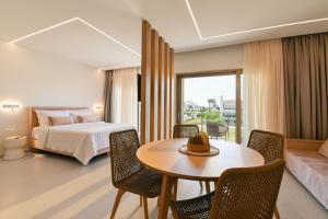 a bedroom with a bed and a table and chairs at IONE Suites in Preveza